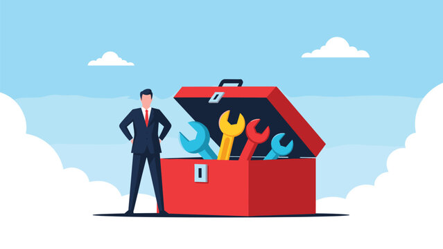 Professional businessman standing with hands on hips next to giant open red toolbox filled with colorful wrenches.