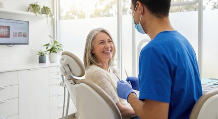 Happy senior woman smiling at male dentist during dental checkup appointment in modern clinic
