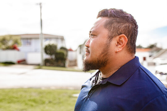 Side profile of Samoan man standing outdoors on a sunny day