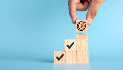 Business success concept with hand placing wooden block with target and checkmarks on blue background
