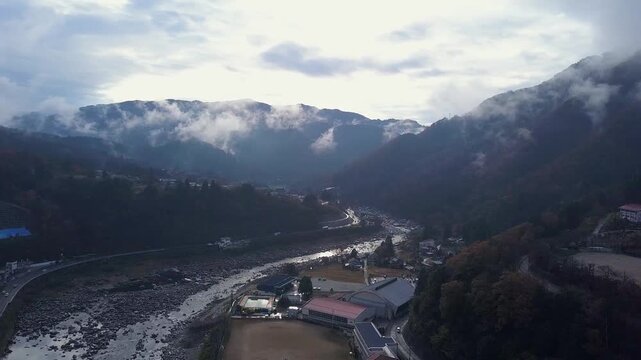Highway follows curve in Kiso River in cloudy Nagiso Japan mtn valley
