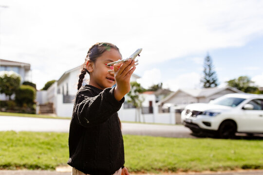 Young Samoan boy playing with an aeroplane toy outdoors