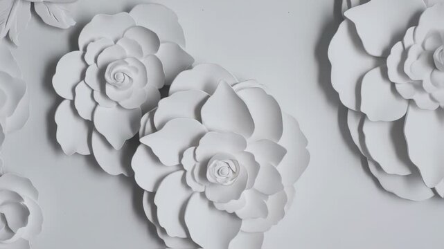 White paper flowers adorn a light gray surface