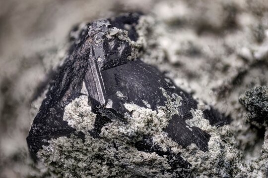 Macro photo of sphalerite crystal from Dalnegorsk deposit. Sharp geometric form and metallic luster on mineral surface. Geological specimen