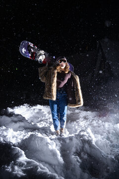 at night in a snowstorm with a snowboard and a pretentious fur coat