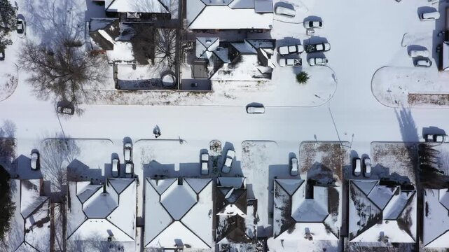 Top-down aerial view of a snow-covered Fort Worth suburban street with people walking in the brisk sunlight after the January 2026 snowstorm