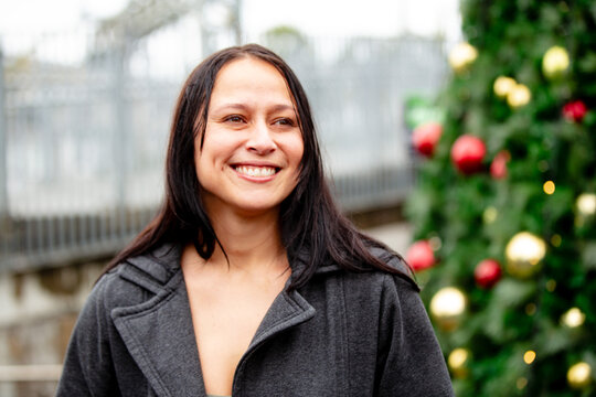 Maori woman in front of a Christmas tree in an urban area in Auckland