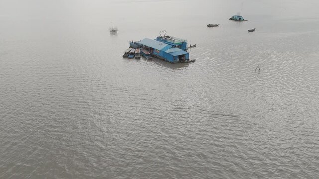 Vues drone 4K de Kampong Phluk, village sur pilotis au Cambodge, le long du M&eacute;kong : maisons flottantes, barques et reflets dor&eacute;s. Id&eacute;al pour projets voyage, culture, nature et Asie authentique.