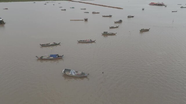 Vues drone 4K de Kampong Phluk, village sur pilotis au Cambodge, le long du M&eacute;kong : maisons flottantes, barques et reflets dor&eacute;s. Id&eacute;al pour projets voyage, culture, nature et Asie authentique.