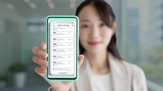 求人検索アプリを表示したスマートフォンを提示する女性