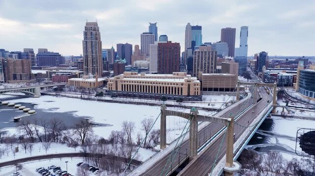 Downtown Minneapolis city skyline showing icy Mississippi River and Hennepin Ave Bridge