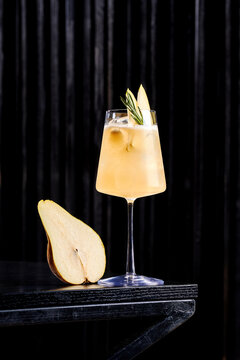 A modern twist on the classic Aperol Spritz, garnished with elegant thin slices of fresh pear and a sprig of mint.