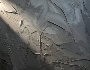 Close-up of thick, textured grey paint with strong diagonal light