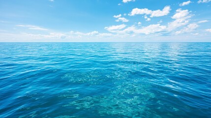 Fototapeta premium Expansive View of Calm Ocean Waters Under a Bright Blue Sky with Fluffy White Clouds