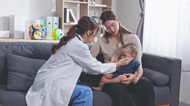 Asian female doctor checking infant with red rash on face, showing allergy or skin irritation symptoms during medical examination in premium clinic or private hospital