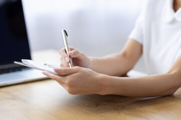 Close Up of Woman Writing Notes on Clipboard at Desk