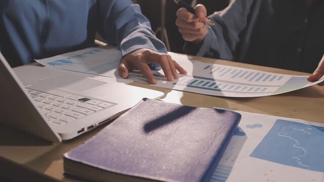 Two concentrated serious business people working in office sitting at the desk with laptop on workplace looking at computer monitor screen analyzing company finances. Accountant job concept.