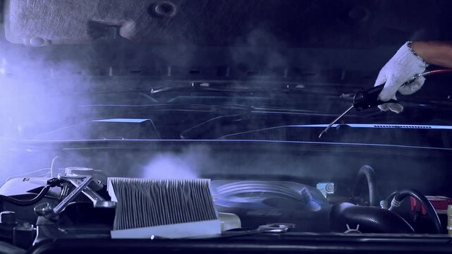 Mechanics are cleaning the engine compartment for maintenance. Filmed in a studio with a digital camera and video edited by a contributor. Slow motion video.