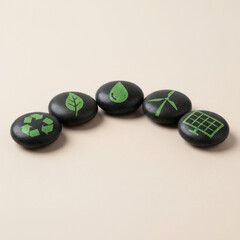 Green Energy Symbols Painted on Dark Stones Arranged in a Row on Neutral Background