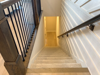 Staircase with wood railing and white shiplap walls