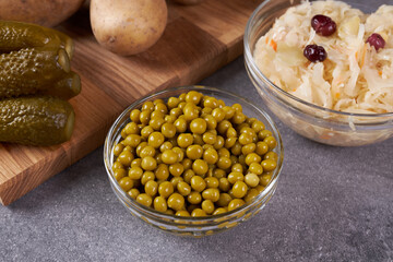 Ingredients for cooking green peas and sauerkraut in bowls on the table