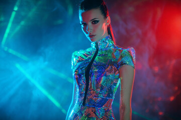 Stunning woman in futuristic holographic dress under neon lights