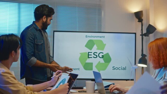 group of multiethnic businesspeople in team meeting,using tablet computer for Net zero,ESG topic presentation on monitor. Sustainable business practice,global warming,earth day,ESG team concept
