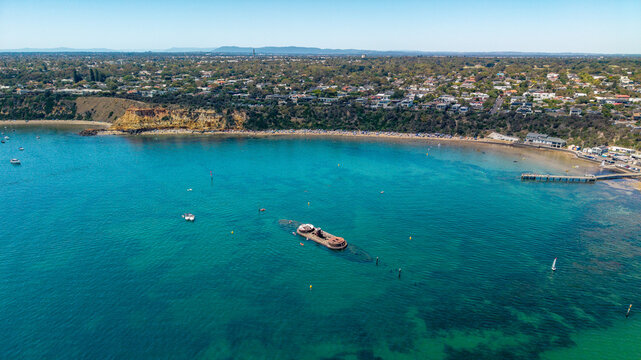 Sunken HMVS Cerberus Wreckage in Blackrock Bay, Australia, with a Lively Beach, Pier, and Coastal Suburb on a Sunny Day.