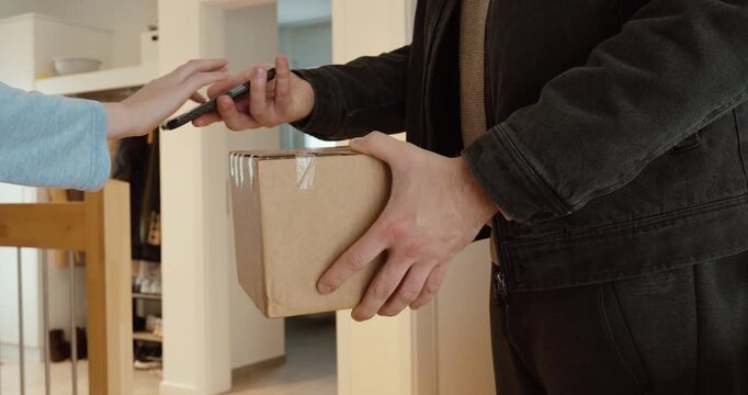 A courier hands over a parcel while the customer signs electronically on a smartphone, then receives the package. Ideal for last-mile delivery, proof of delivery, contactless logistics, e-commerce ful