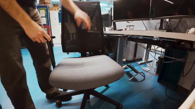 A person checks and tests an office chair, then sits down and adjusts posture at a workstation. Ideal for workplace ergonomics, comfort, productivity, remote work, and office equipment evaluation conc