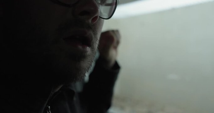 Moody close-up of a man near a window breathing heavily, suggesting panic, exhaustion, or emotional stress in a dark cinematic atmosphere. Ideal for anxiety, burnout, tension, and mental health storyt