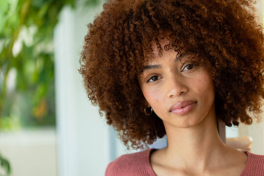 African American adult woman posing, looking toward camera at home wearing small hoop earrings