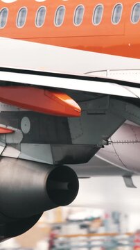 Orange and white airplane engine taxiing on runway