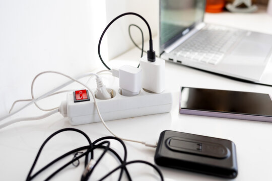 Plug in power outlet Adapter cord charger of smart phone on table. Smartphone and power bank on the table in the home office.