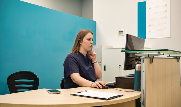 Medical office receptionist working at a computer