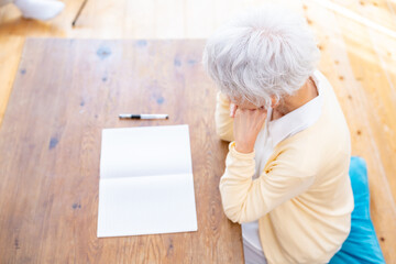 ノートを前に悩む女性