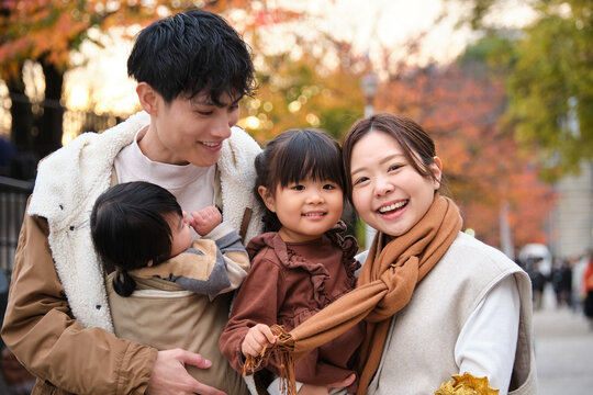 Smiling family with children enjoying autumn together outdoors in Tokyo