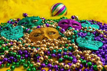Mardi Gras beads in glittering yellow, green, purple, and gold. Sparkling festive background for Mardi Gras in traditional colors. © Mantas Žiličius