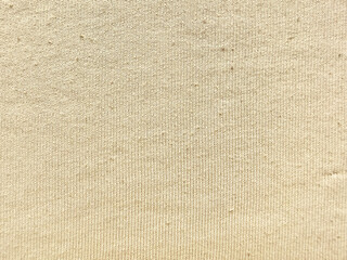 Fototapeta premium beige ribbed knit fabric texture closeup showcasing soft woven threads subtle shadows and gentle folds against pale blue backdrop evoking cozy tactile warmth