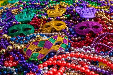 Fototapeta premium Mardi Gras beads in glittering yellow, green, purple, and gold. Sparkling festive background for Mardi Gras in traditional colors.