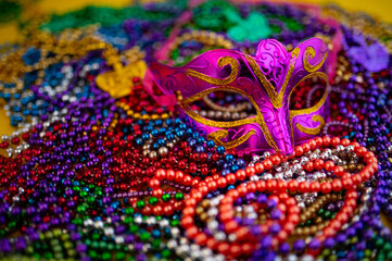 Obraz premium Mardi Gras beads in glittering yellow, green, purple, and gold. Sparkling festive background for Mardi Gras in traditional colors.