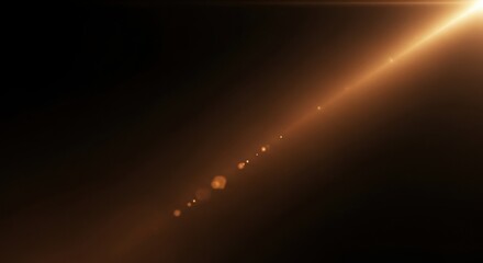 Abstract golden lens flare effect with bright light ray and glowing particles on black background creating dramatic illumination