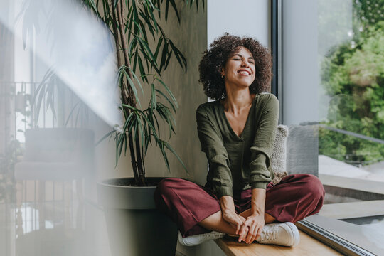 Businesswoman relaxing near office window with a smile