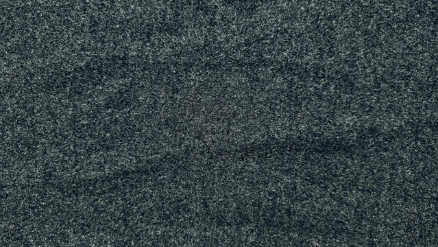 moody closeup texture of charcoal gray wool fabric with intricate speckled fibers and subtle depth for design backgrounds