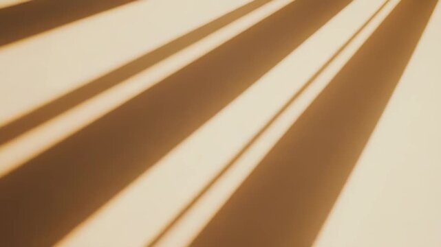 Sunlight beams casting a natural abstract pattern with strong diagonal shadows against a warm beige textured wall surface, providing a minimalist and atmospheric background
