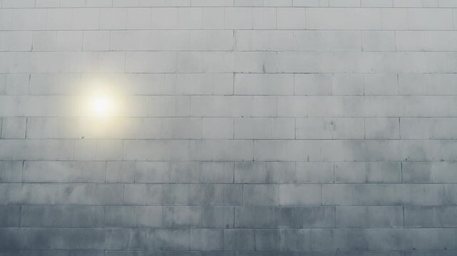 Minimalist concrete block wall forming a weathered texture background with a bright sun flare on the surface and a clean ground area below, creating ample copy space