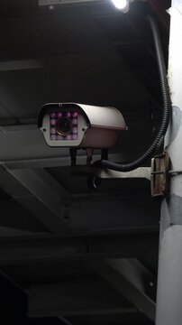Vertical view of a surveillance camera on a train station platform.