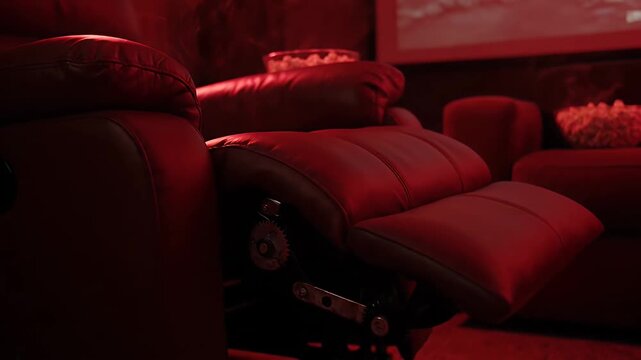 Luxurious red leather reclining chair opening in home cinema