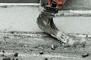 excavator loader breaking road surface