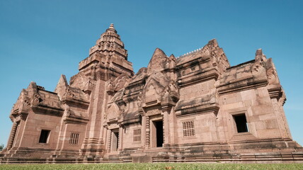 Fototapeta premium The intricate pink sandstone architecture and carved lintels of the main sanctuary at Phanom Rung Historical Park in Buriram, Thailand